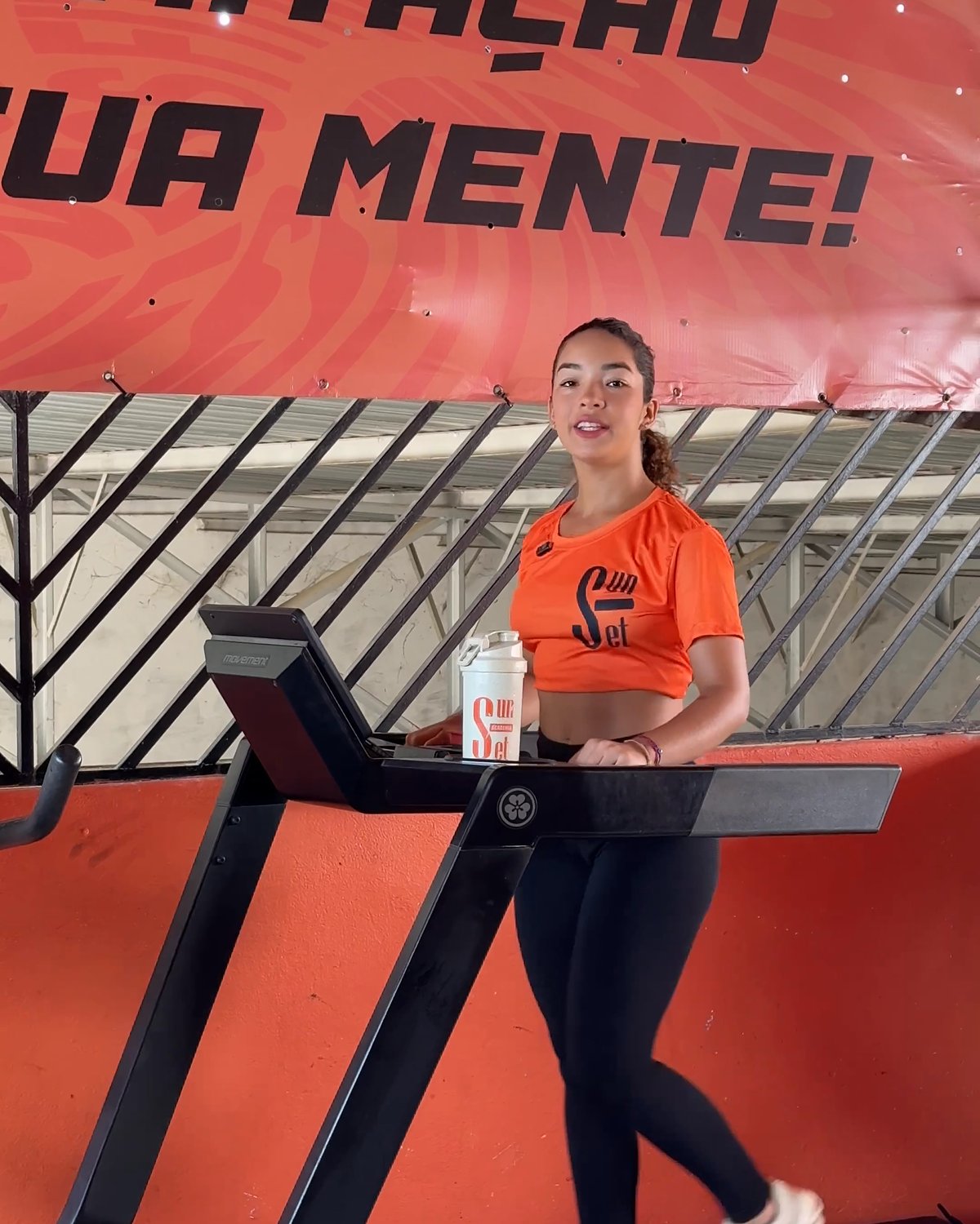 Aluna caminhando na esteira no andar de cardio
